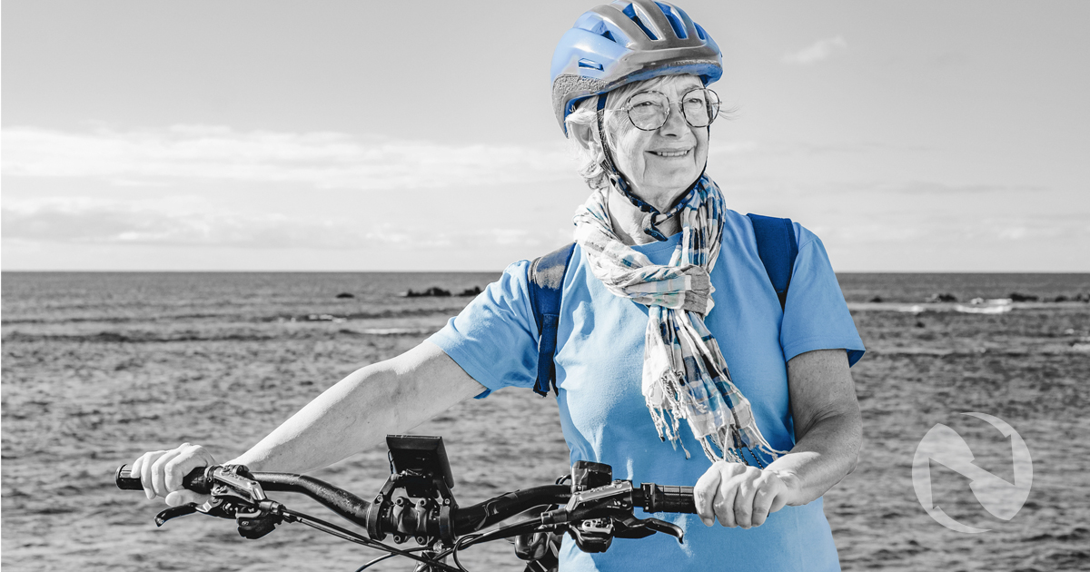 A retired woman enjoys a day biking at the beach, confident that her financial strategy means she won't outlast her money.
